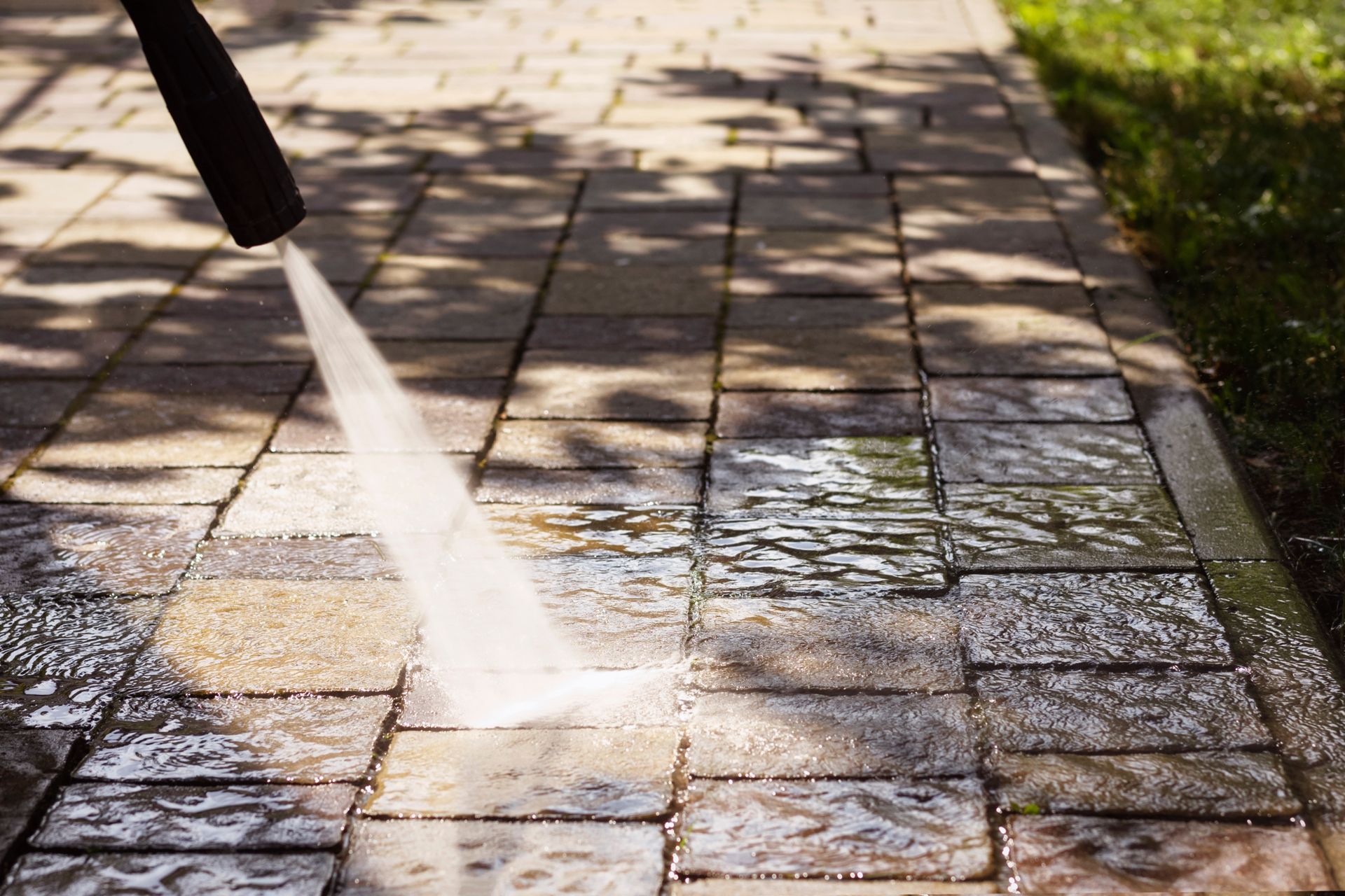 Power washer cleaning a brick patio