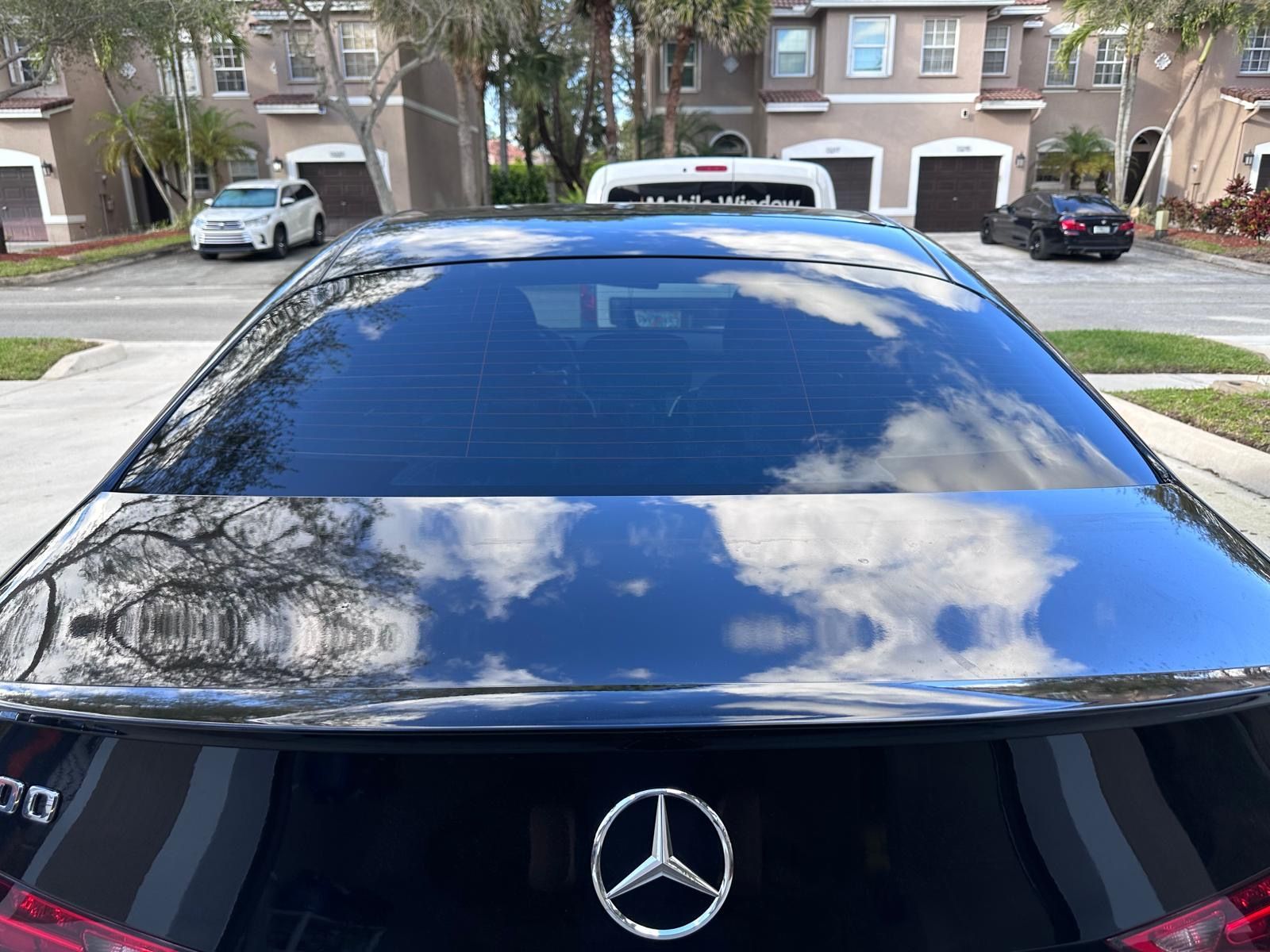 A black mercedes is parked on the side of the road