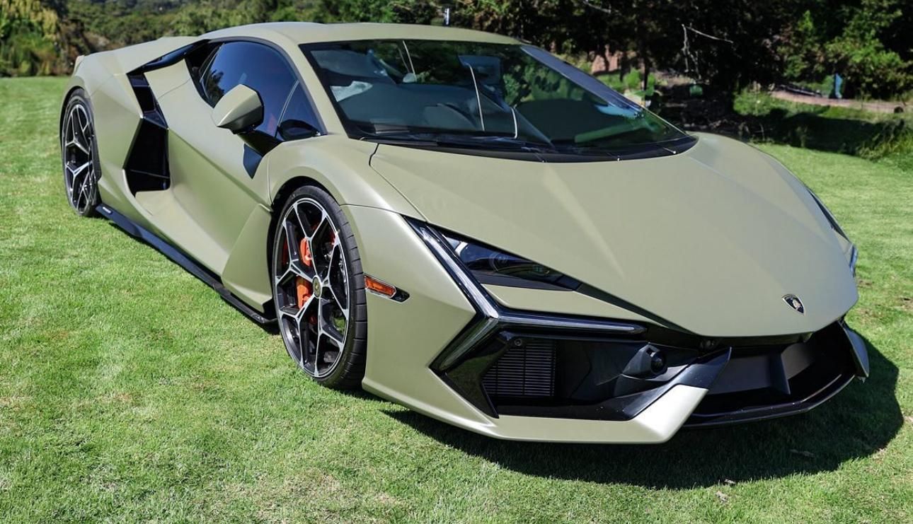 A green lamborghini is parked in a grassy field.