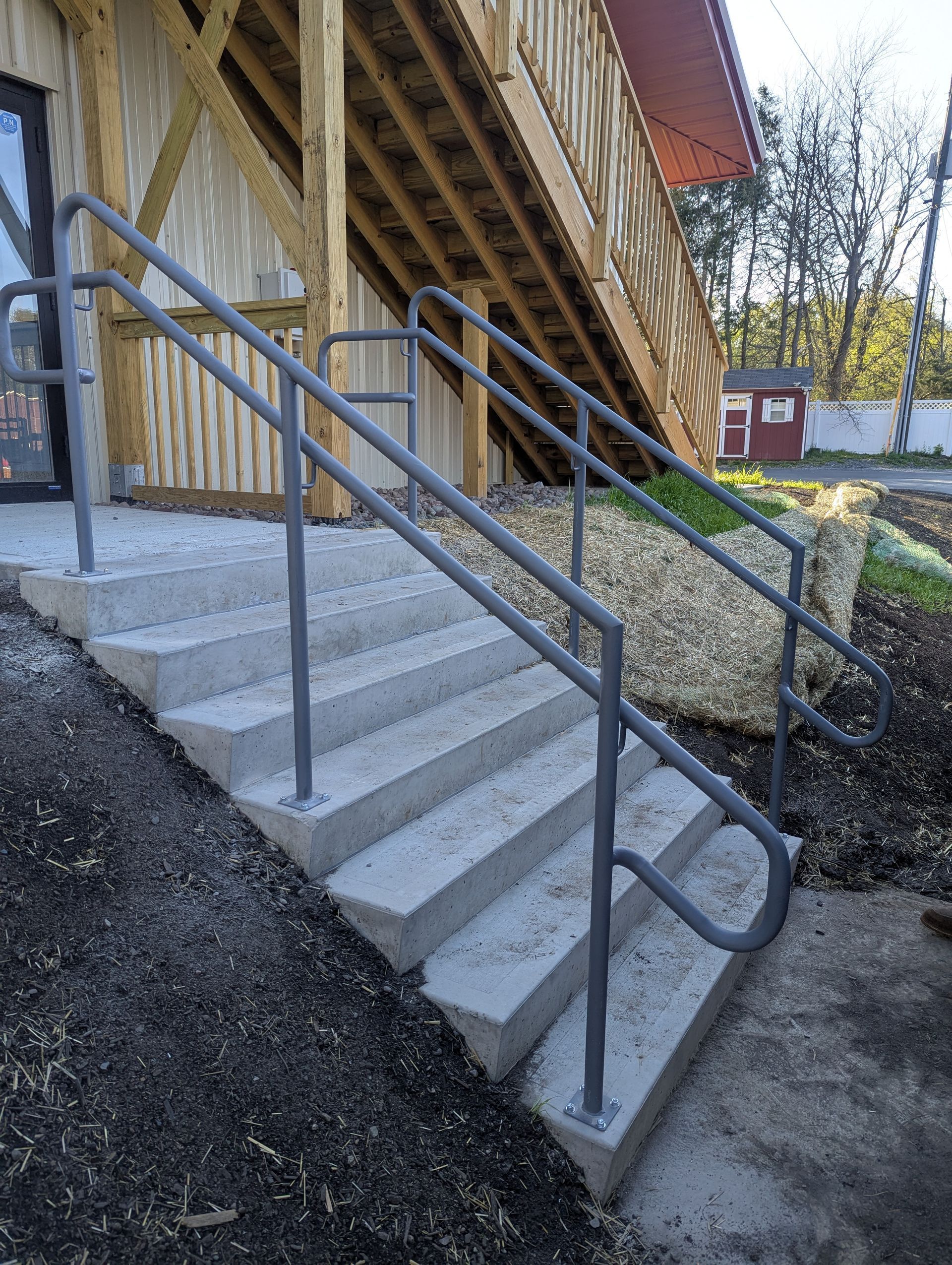 Yellow handrails on a concrete ramp leading to a loading dock of a commercial building.