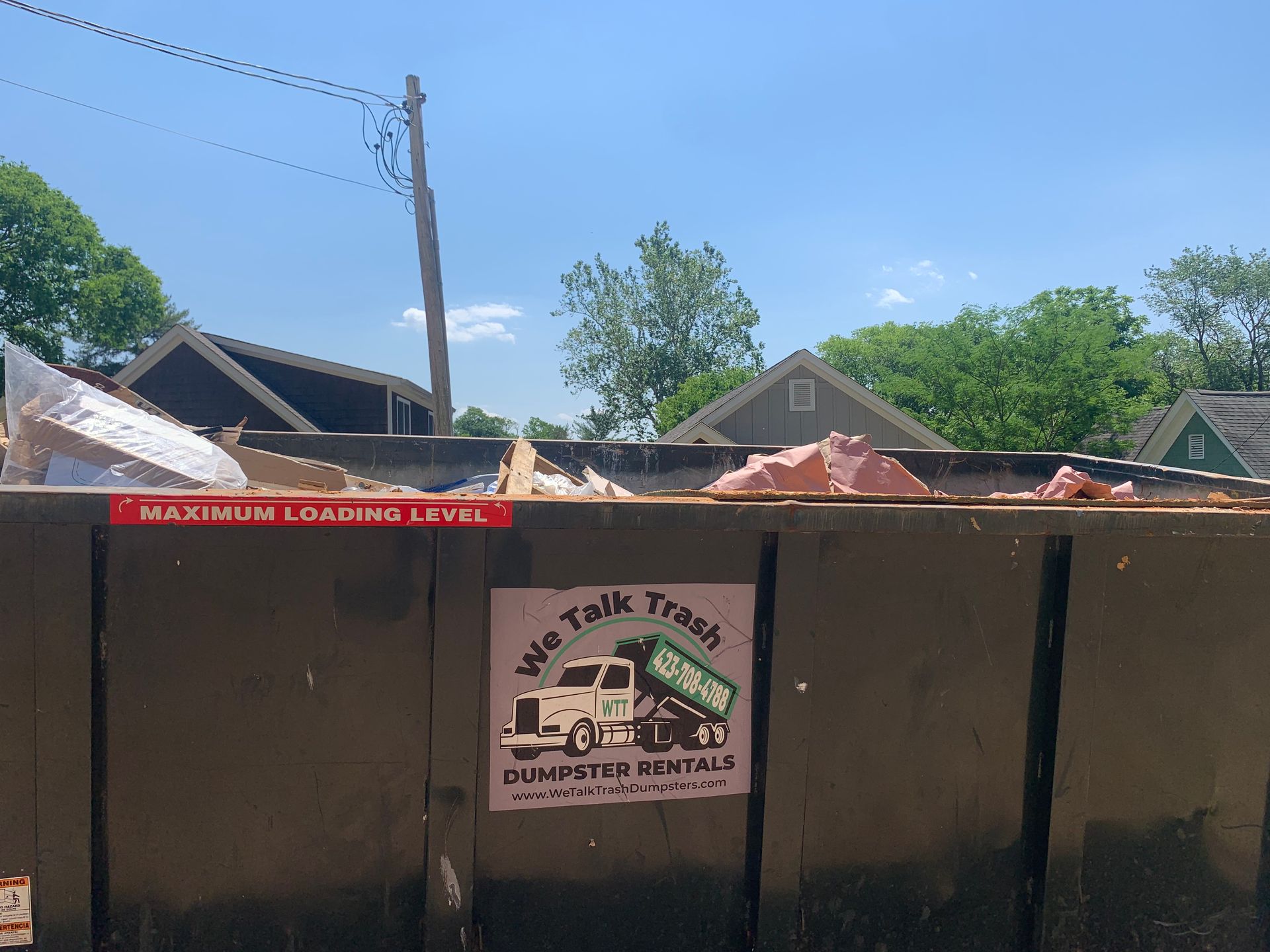 dumpster with we talk trash logo on it. 