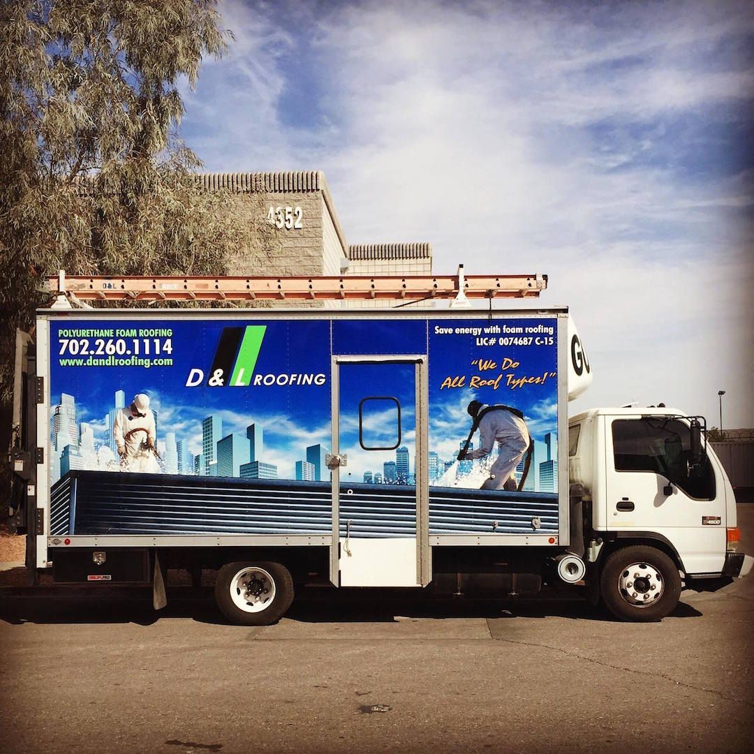 A white truck with a blue and white graphics for d & l roofing