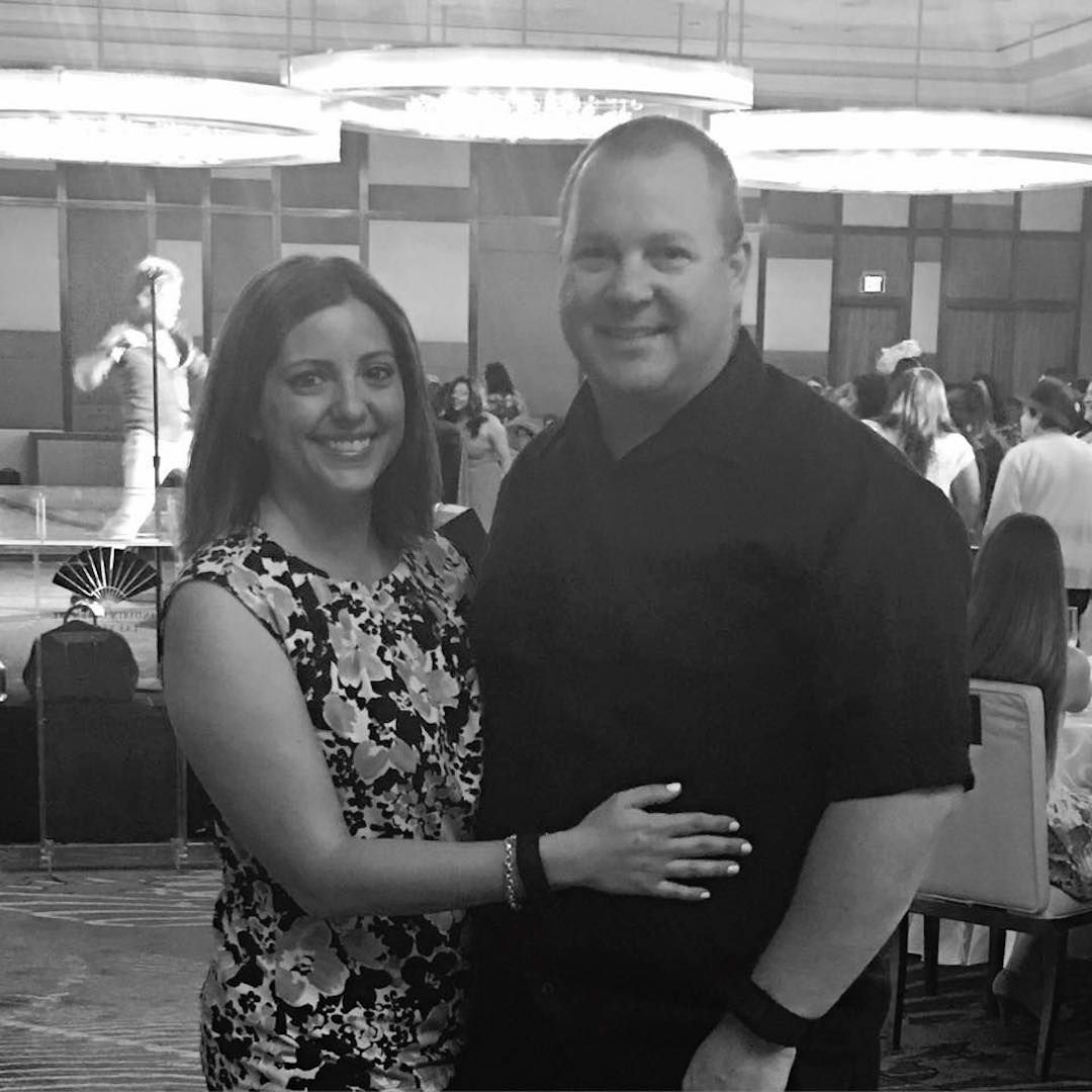 A man and a woman are posing for a picture in a black and white photo.