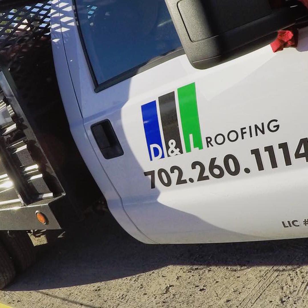 A white roofing truck is parked on the side of the road