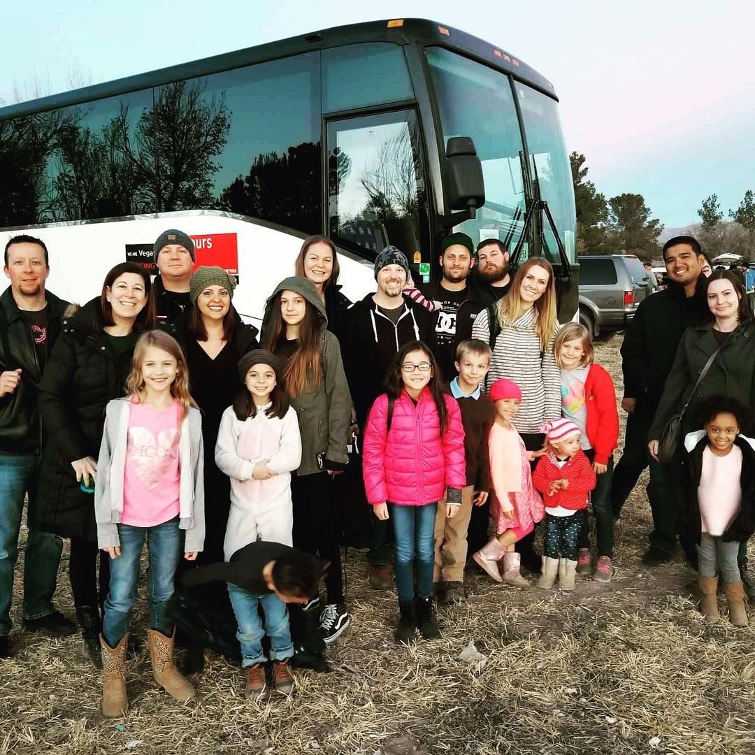 A large group of people standing in front of a bus