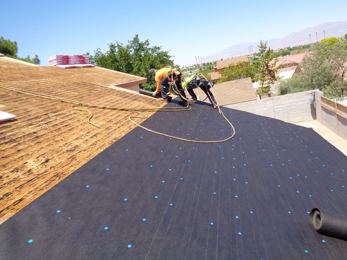 A roof with underlayment and shingles being installed