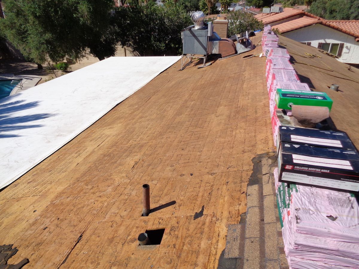 A roof with stacks of underlayment ready for installation