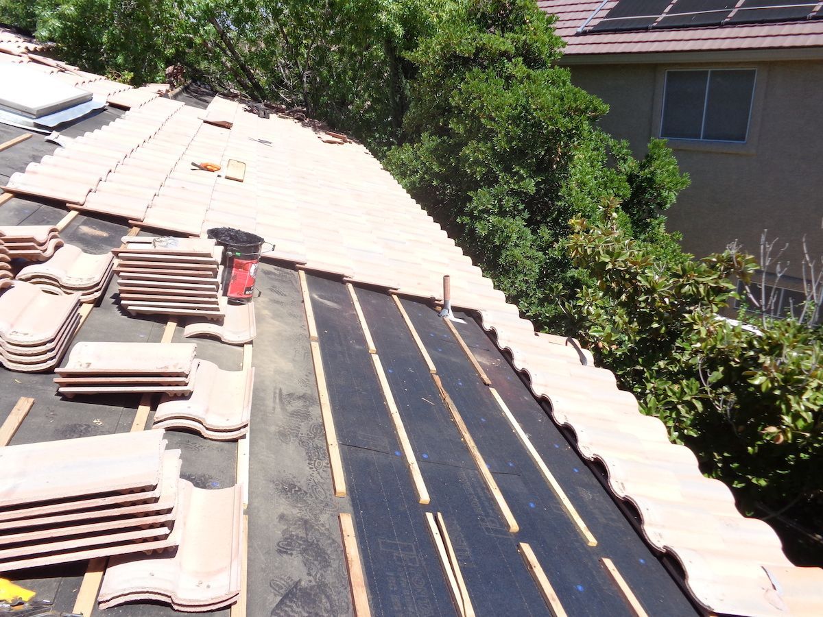 A roof with a lot of tiles on it ready for installation.