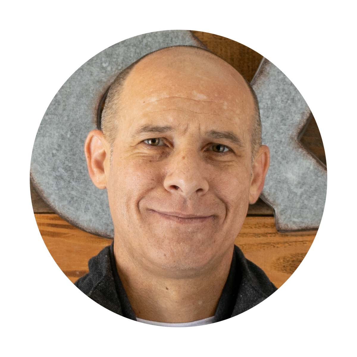 A man with a bald head is smiling in a circle.