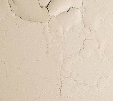 A close up of a cracked white wall.