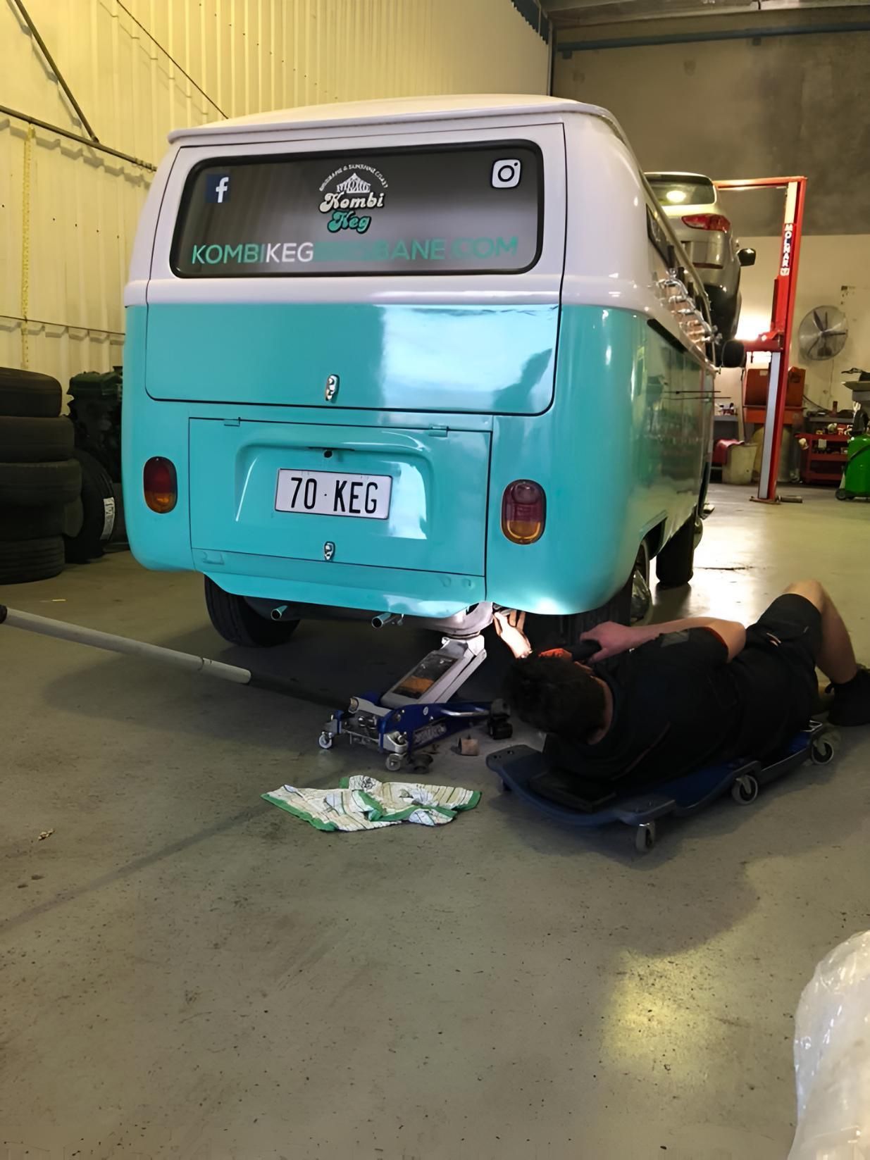Man is Working on a Blue and White Van in a Garage — Noosa Mechanical in Noosaville, QLD