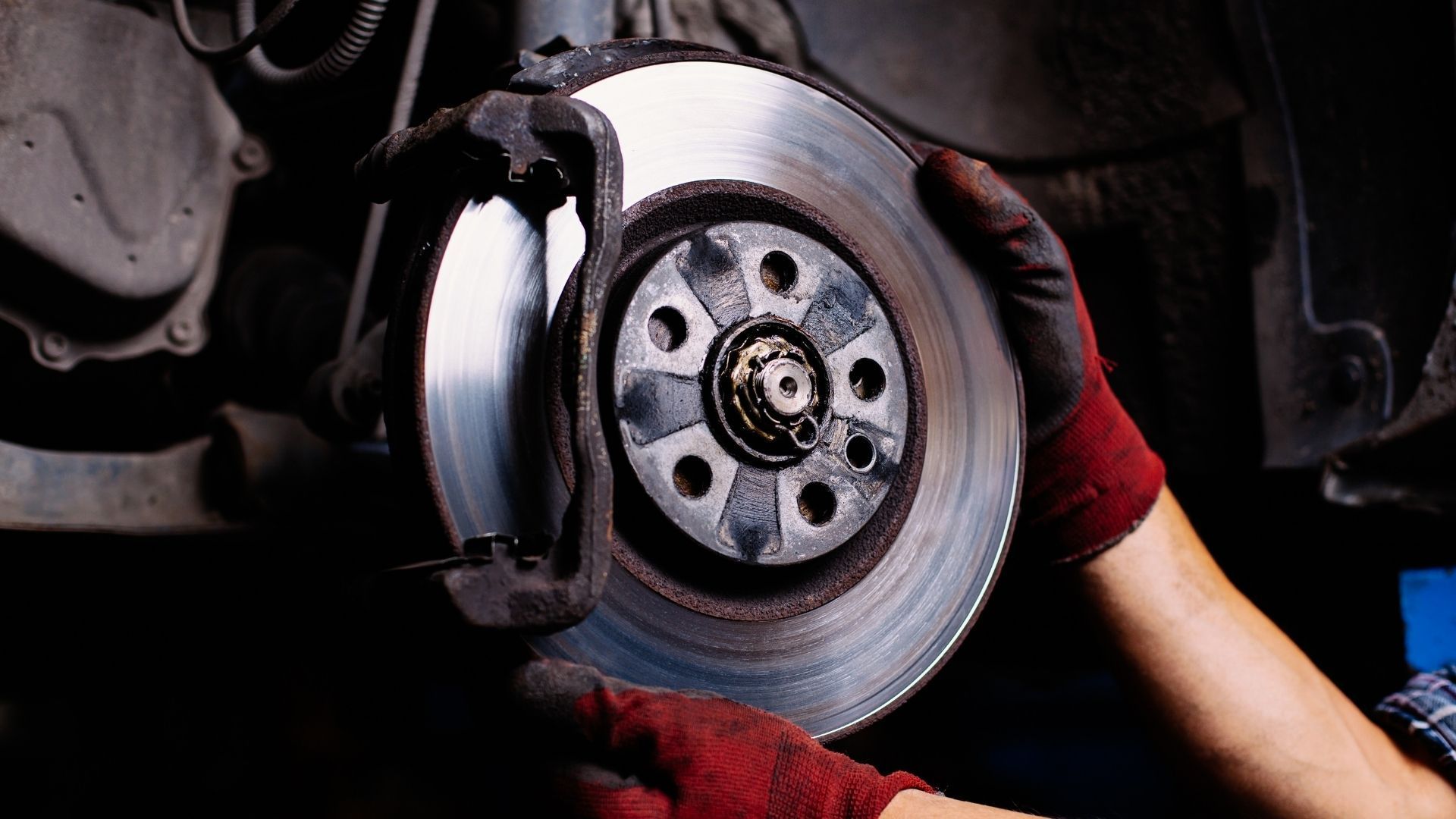 A person is fixing a brake disc on a car.