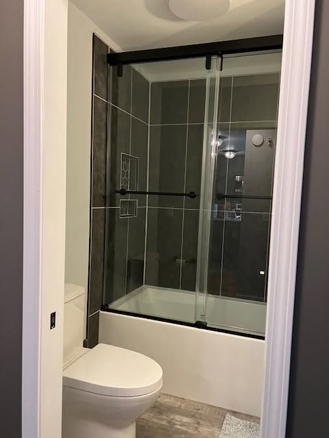 Small bathroom with a white toilet and a glass-enclosed shower.
