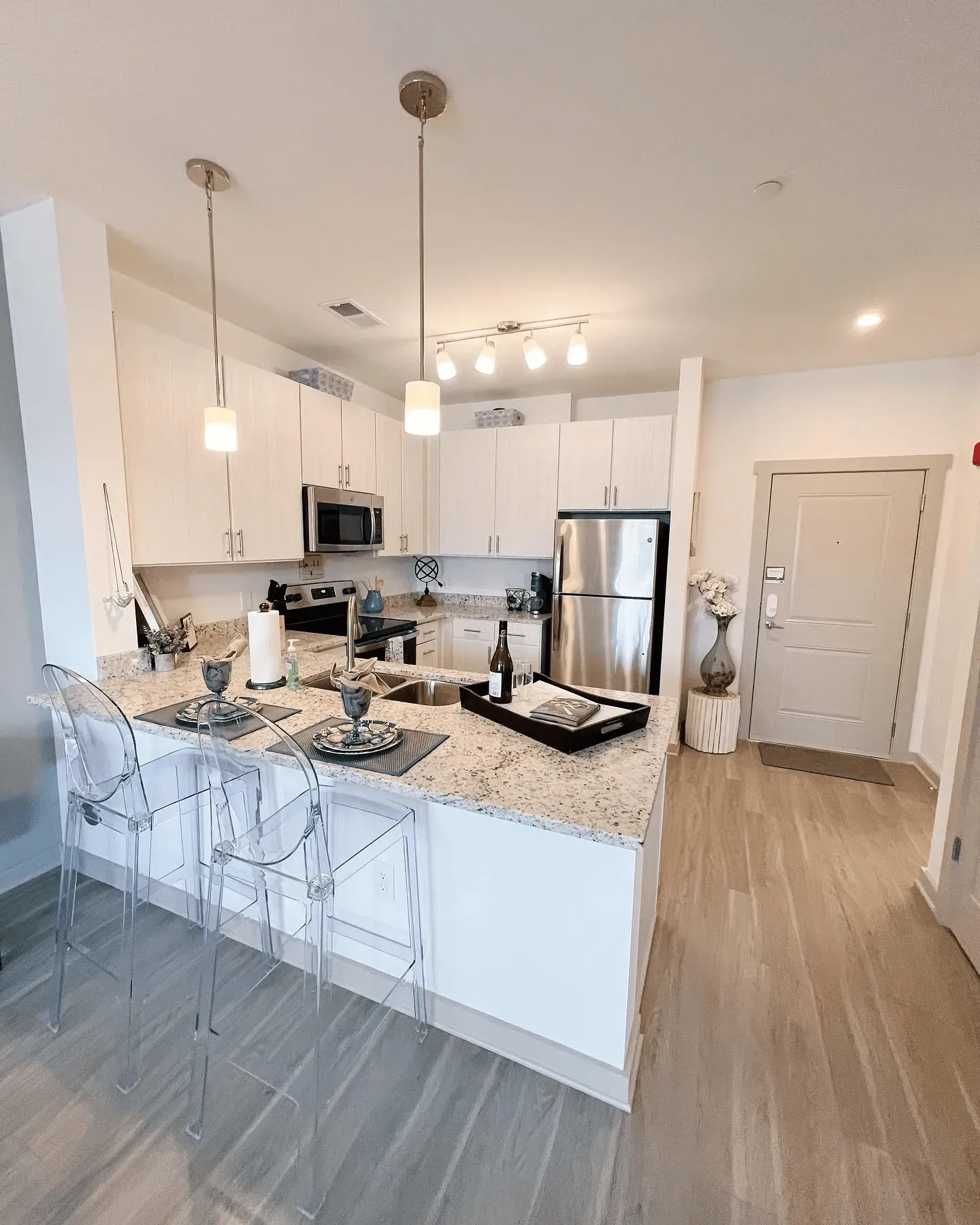 Modern kitchen with granite countertops, stainless steel appliances, and island seating.