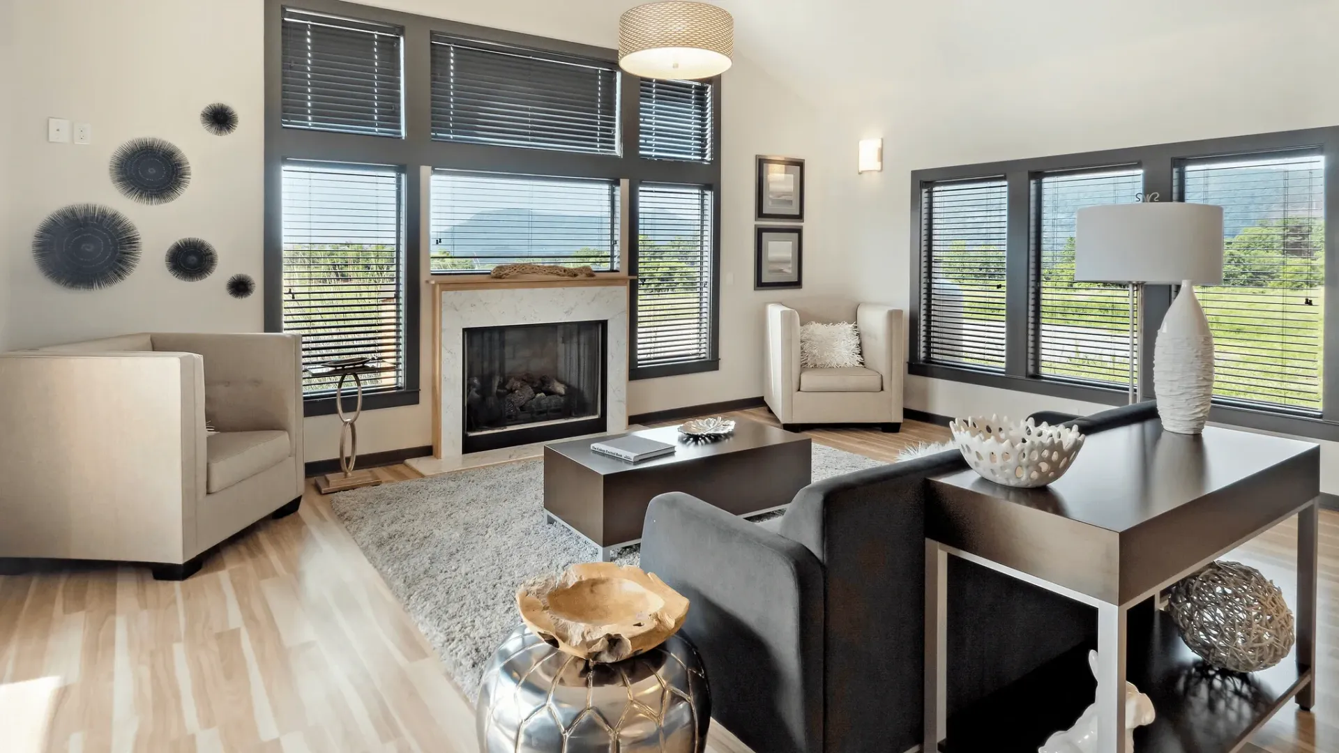 Modern living room with a fireplace and large windows.