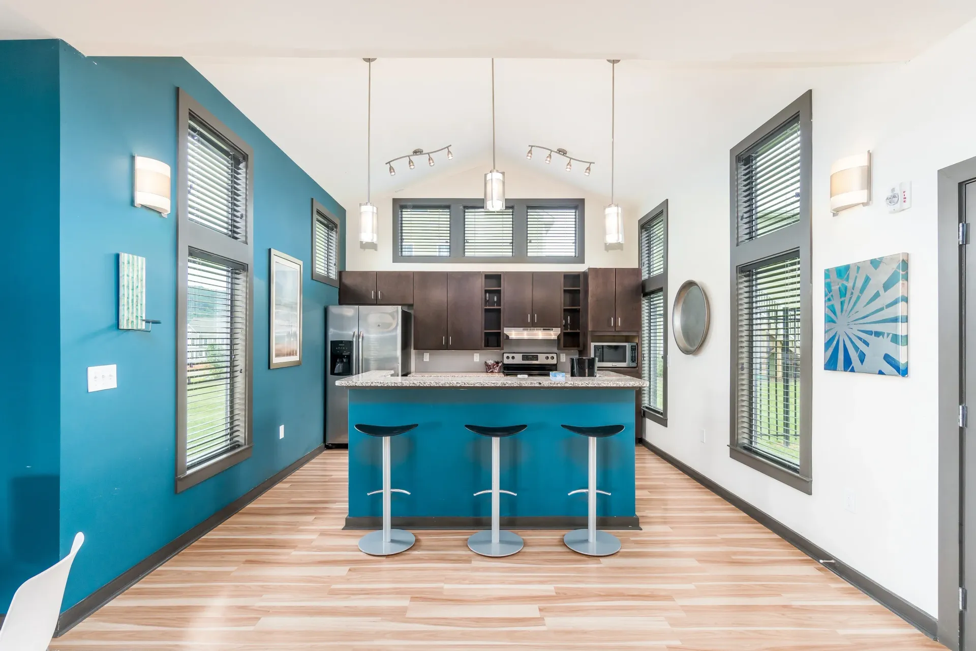 Modern kitchen with island seating and stainless steel appliances.