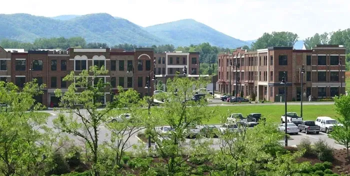 Exterior view of apartment buildings with mountains in the background.
