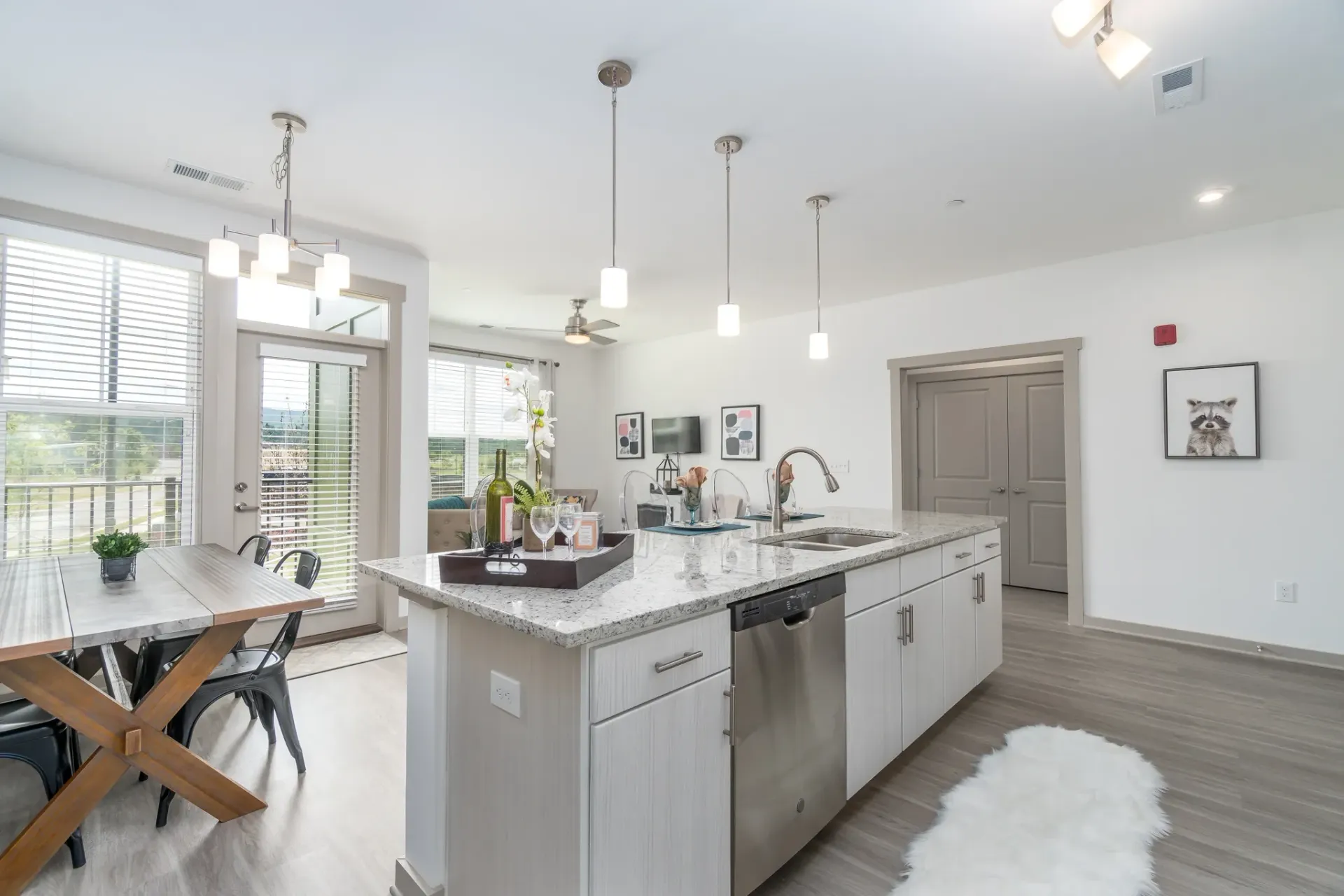 Modern kitchen with island and dining area, featuring granite countertops, stainless steel appliances, and natural light.