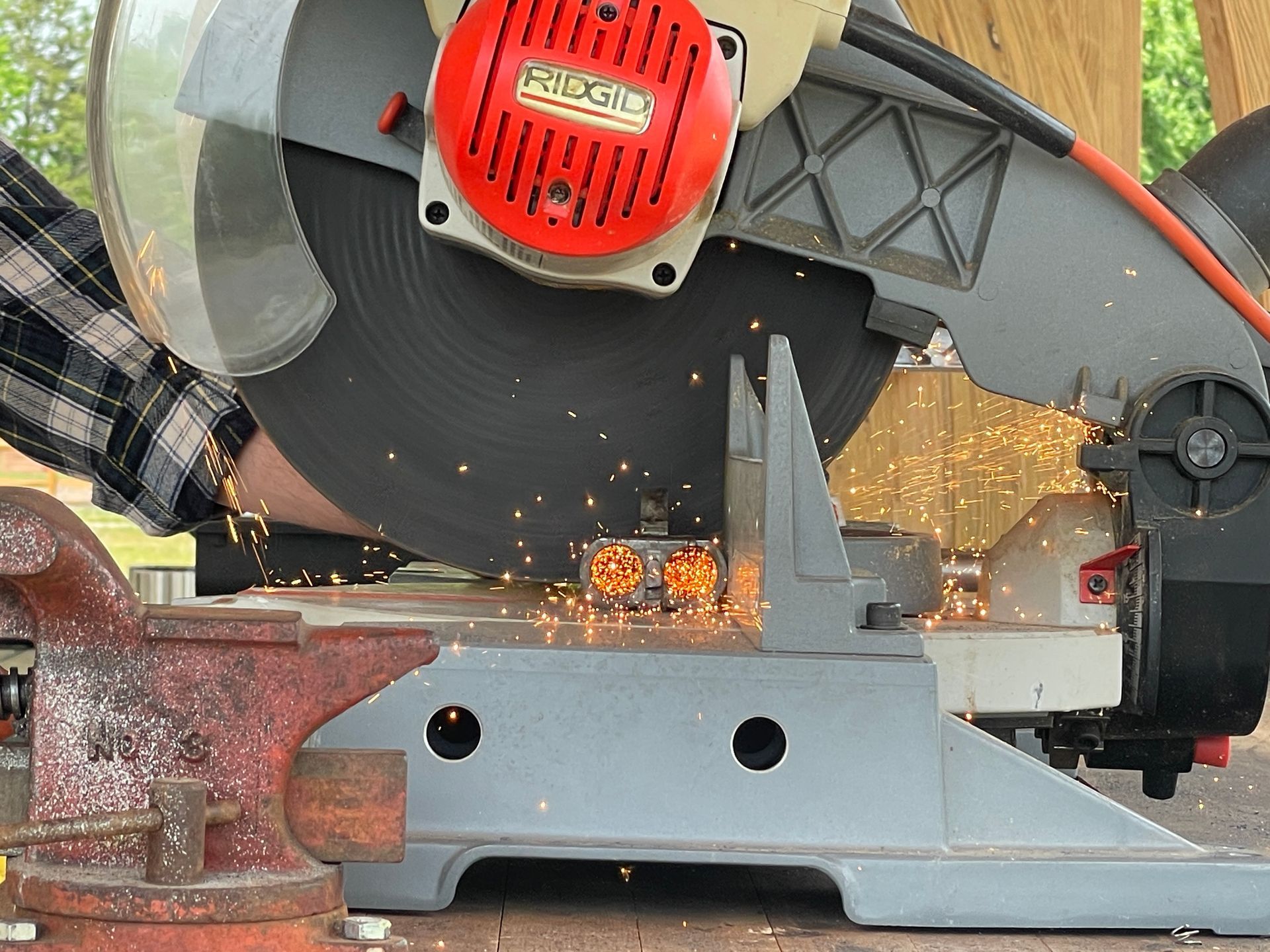 Person cutting metal with a circular saw, creating sparks.