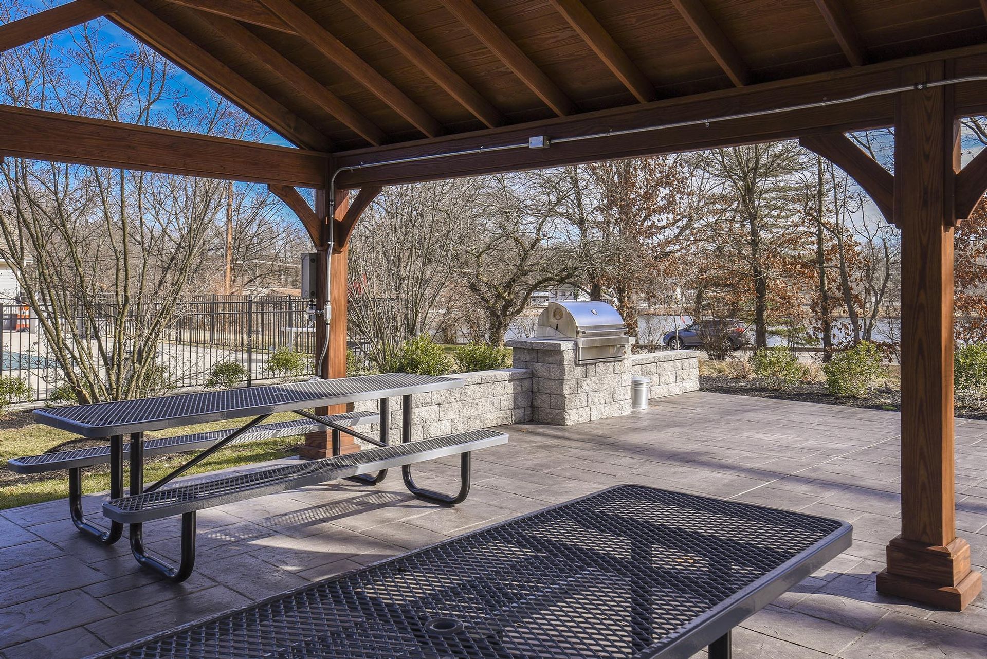 Covered wooden pavilion with metal picnic tables and a built-in grill at Holly Court, offers apartments in Pitman, NJ.