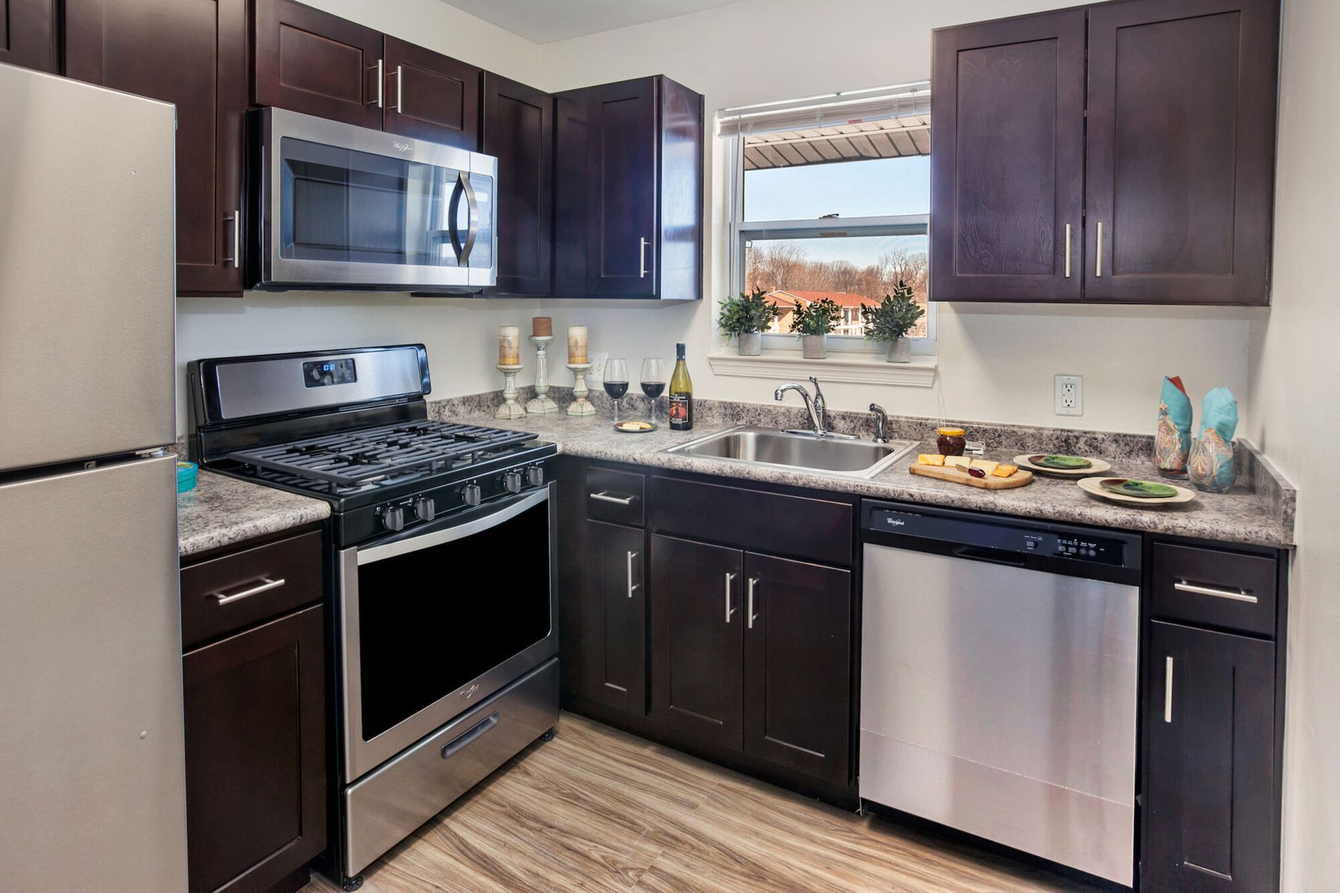 Kitchen with dark cabinets, stainless steel appliances, and a granite countertop.