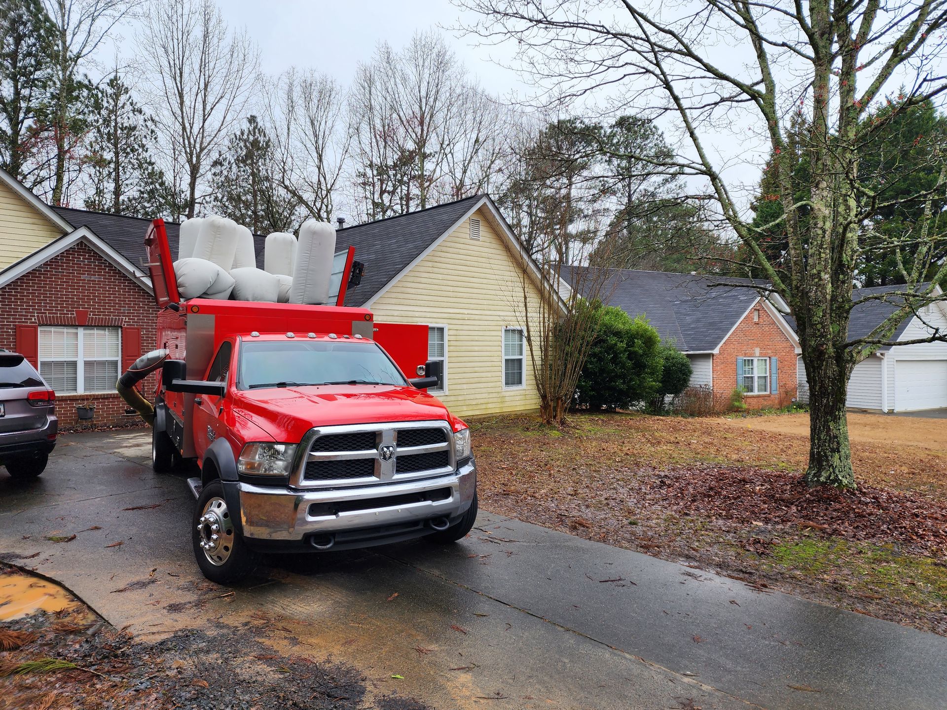 A red truck is parked in front of a house.