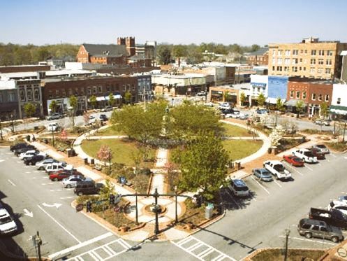 An aerial view of a small town with a park in the middle