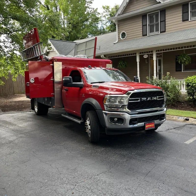 Red fire truck parked on a residential street beside a house.