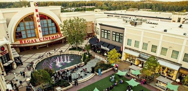 An aerial view of a shopping mall with a fountain in the middle of it.