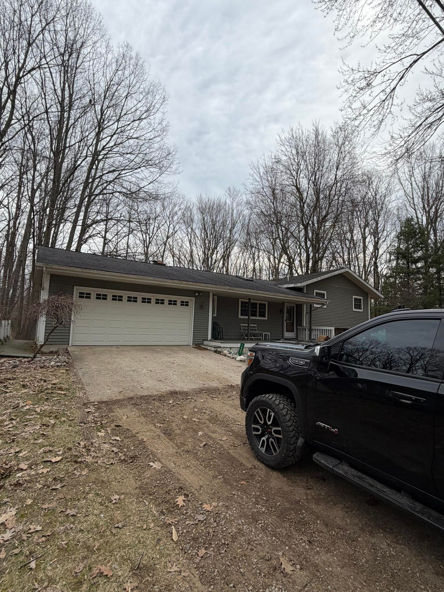 House with a two-car garage and black truck parked in the driveway on an overcast day
