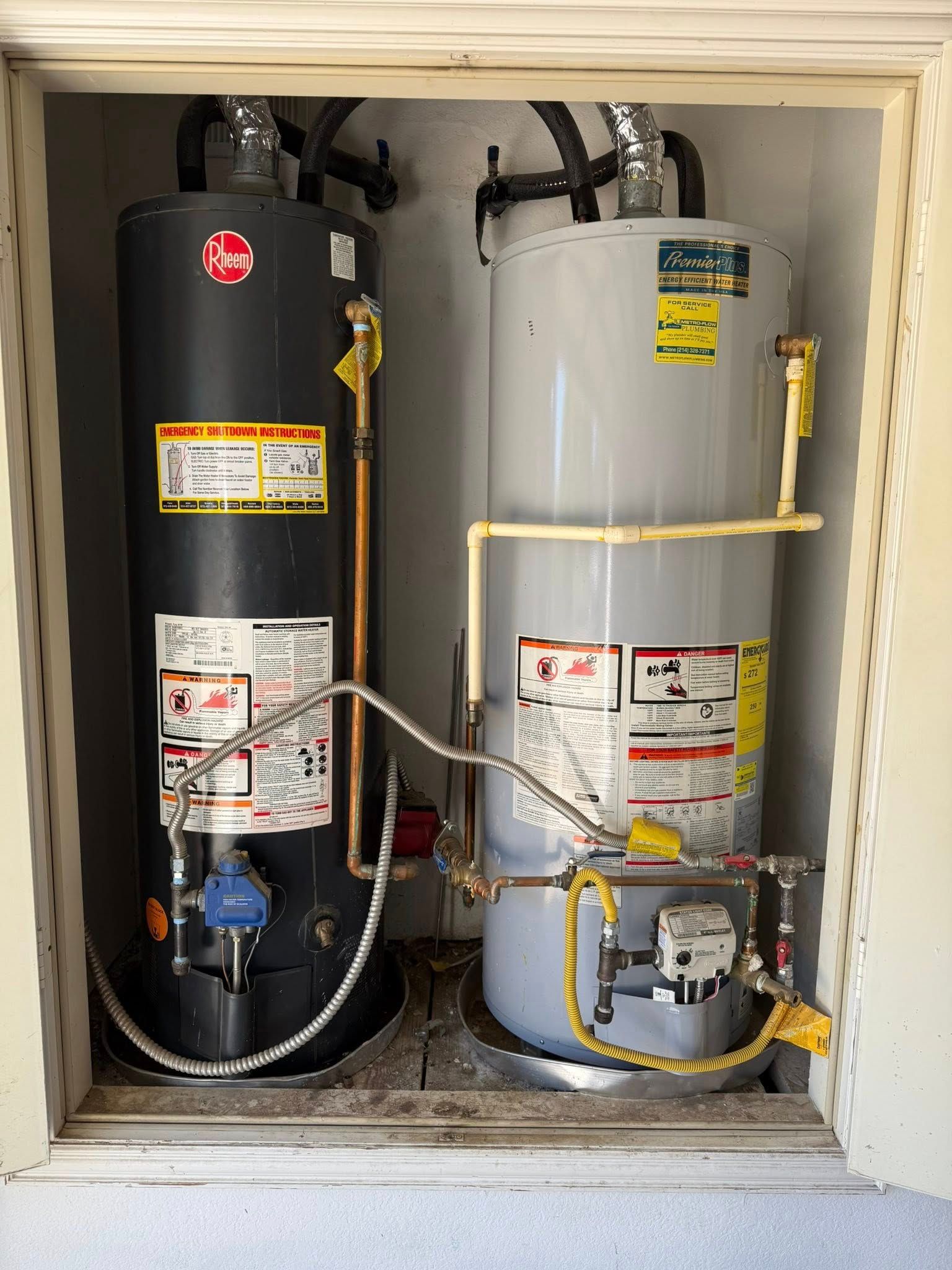 Two upright water heaters, one black and one gray, installed side-by-side in a small utility closet.