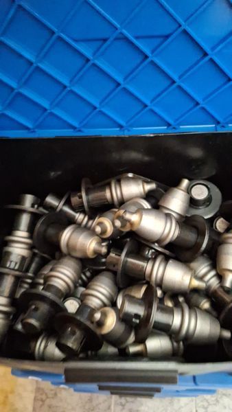 Contenitore blu pieno di tubi o raccordi metallici impilati uno sull'altro
