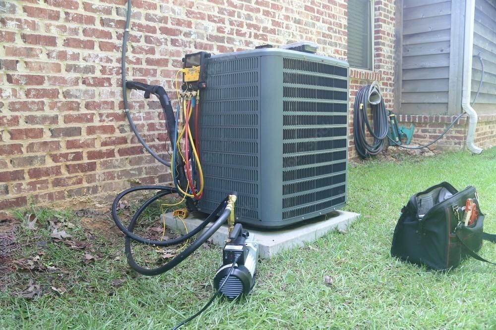 A man is working on an air conditioner in a living room.