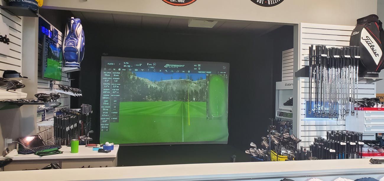 A golf store with a large screen displaying a golf course.