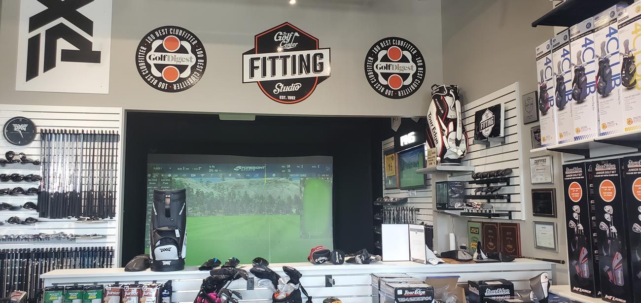 A store filled with lots of golf equipment and a fitting room.