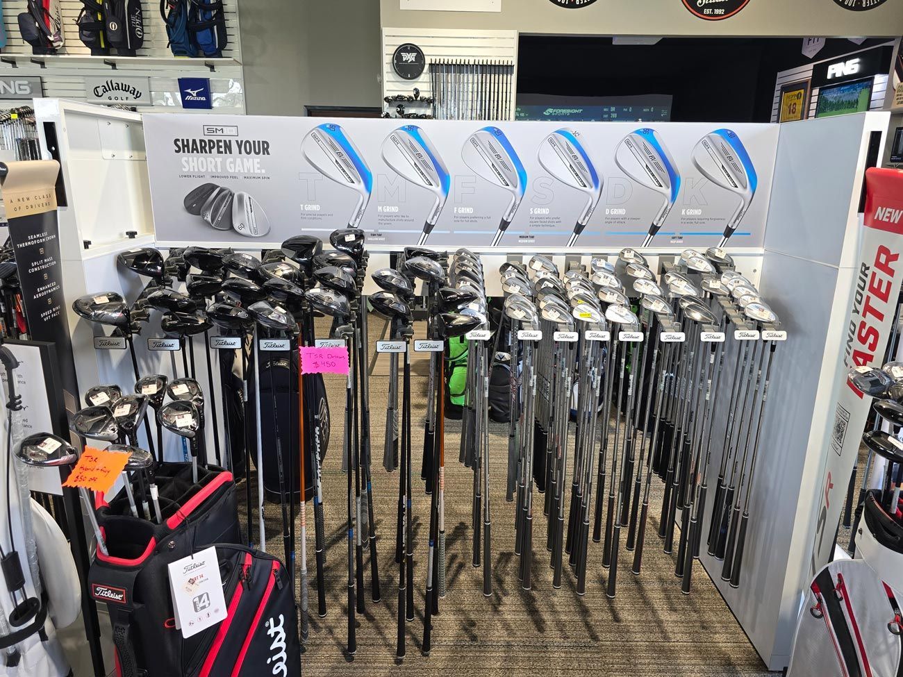 A bunch of golf clubs are displayed in a store.