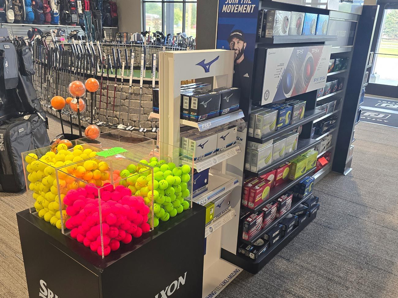 A bunch of tennis balls are sitting on a table in a store.