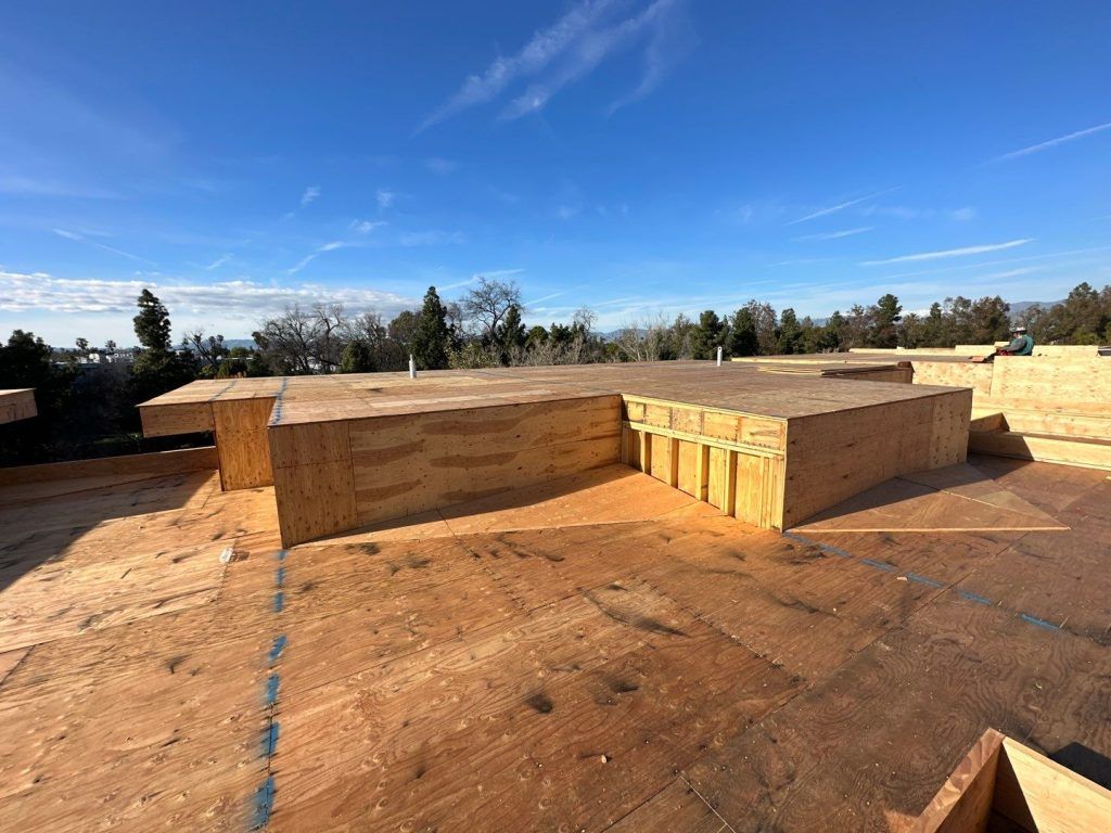 Wooden retaining walls on a dusty construction site under a bright blue sky