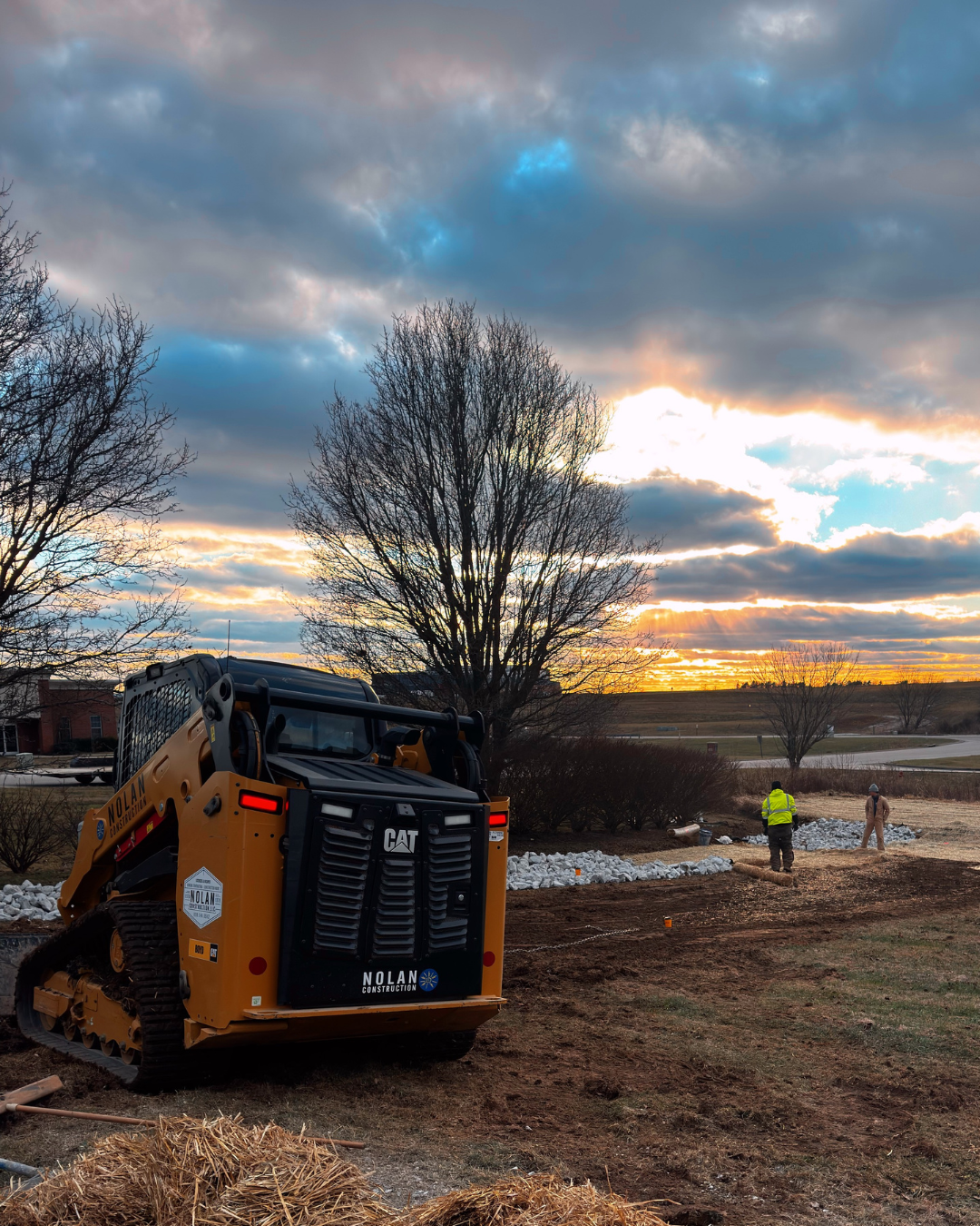 a small excavator is digging a hole in the dirt in a field .