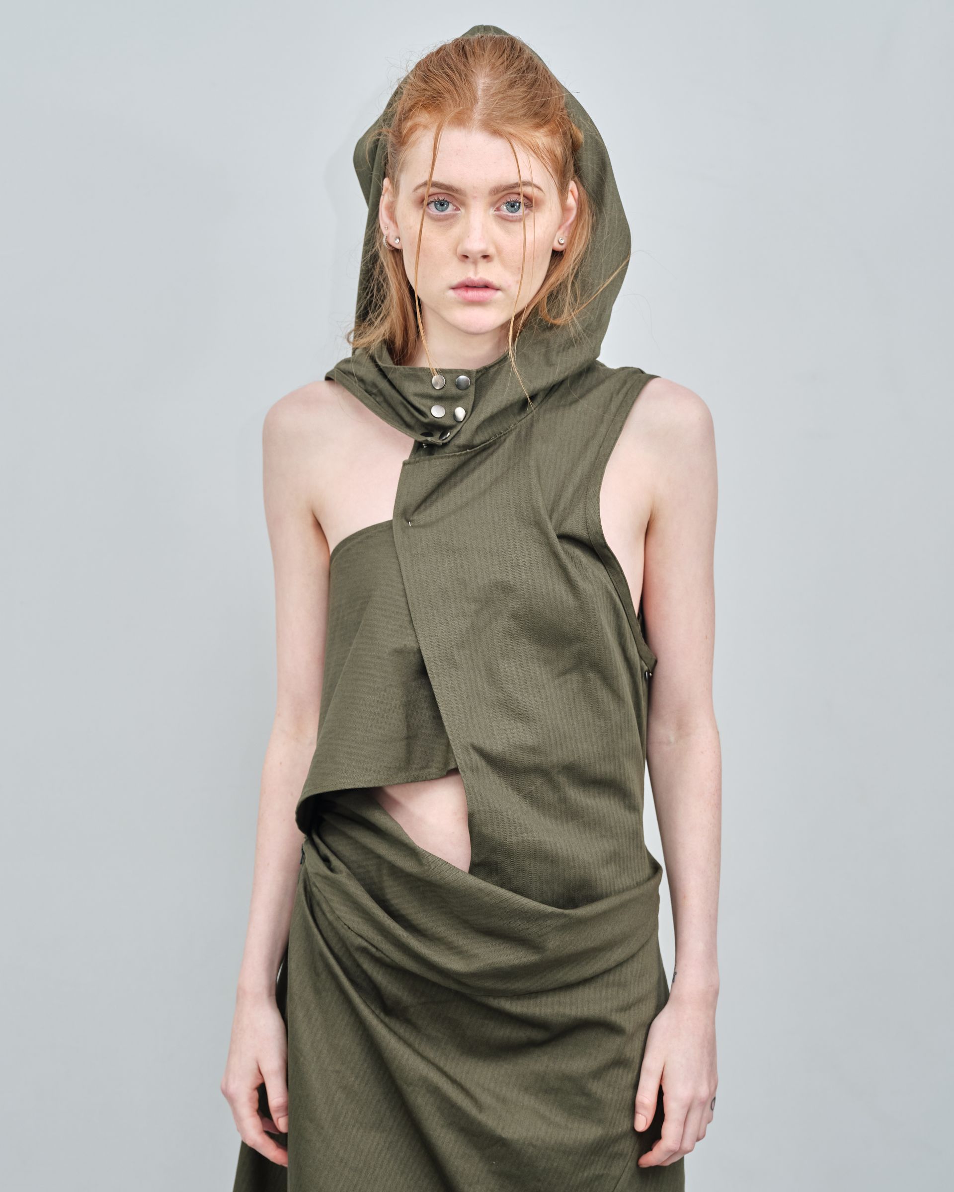 A woman in a green dress with a hood on her head