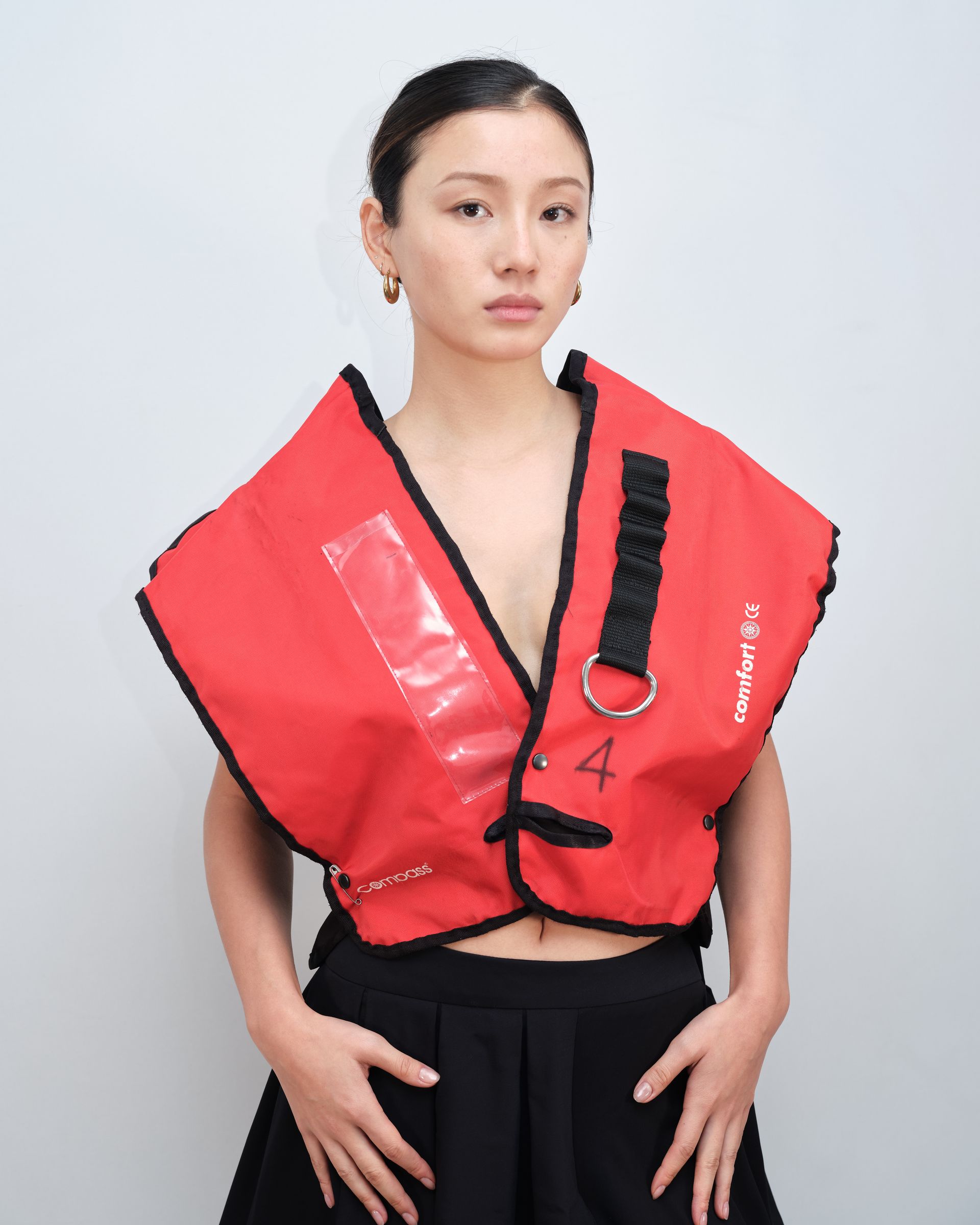 A woman wearing a red vest with the letter a on it