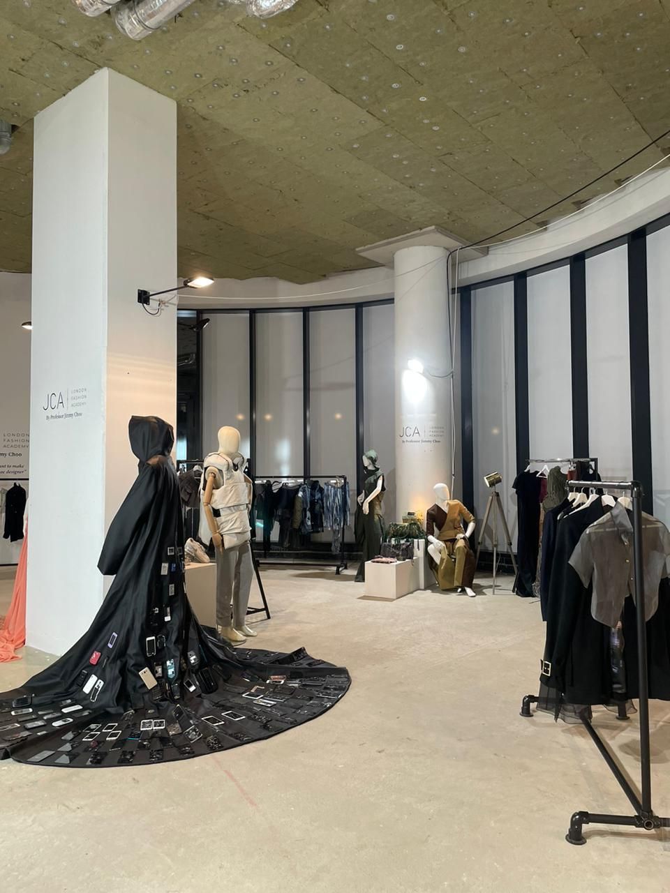 A large room with a lot of clothes hanging on racks