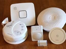 A group of smoke detectors are sitting on top of a wooden table.