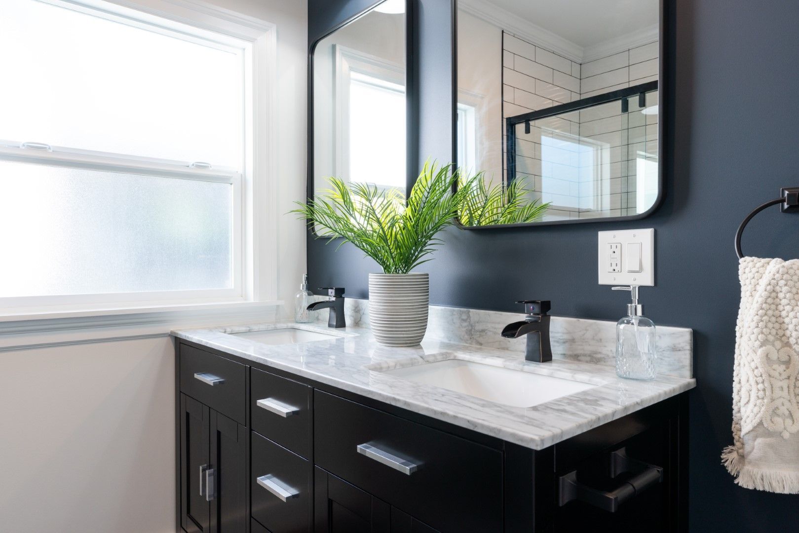 A picture of white marble sinks and faucets in a bathroom in Puyallup, WA