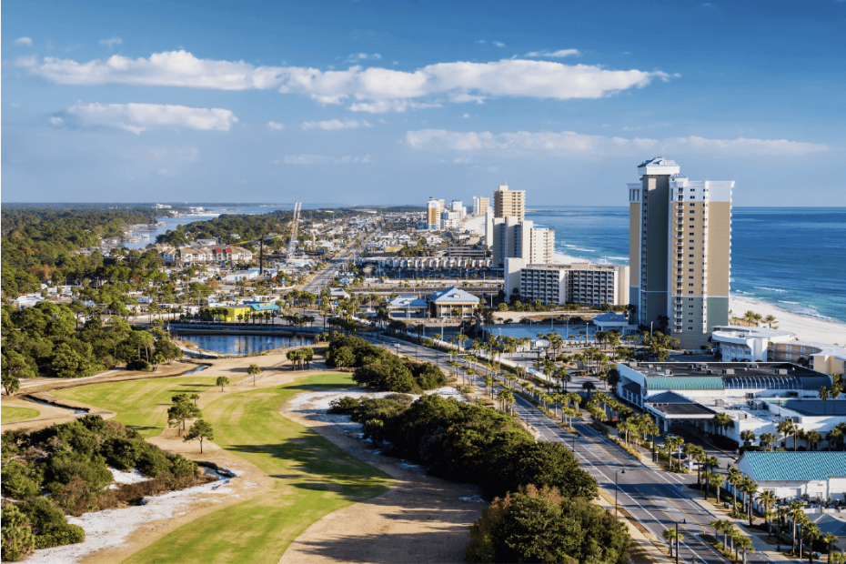 Aerial view of Panama City Beach with beachfront hotels, golf course, and ocean.