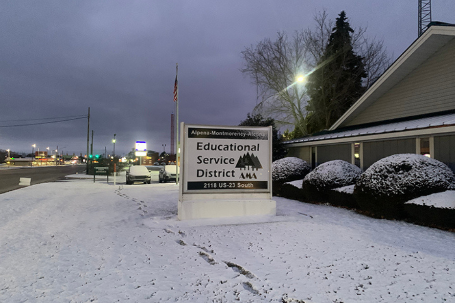 Sign for the Alpena-Montmorency-Alcona Educational Service District in the snow.