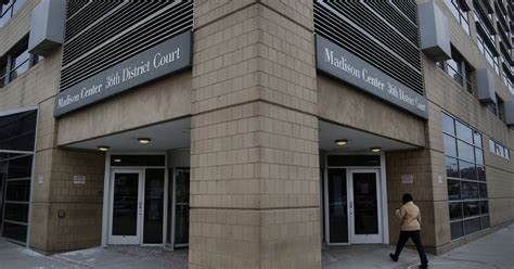 Exterior of Madison Center 3rd District Court; a person walks in front of the building.