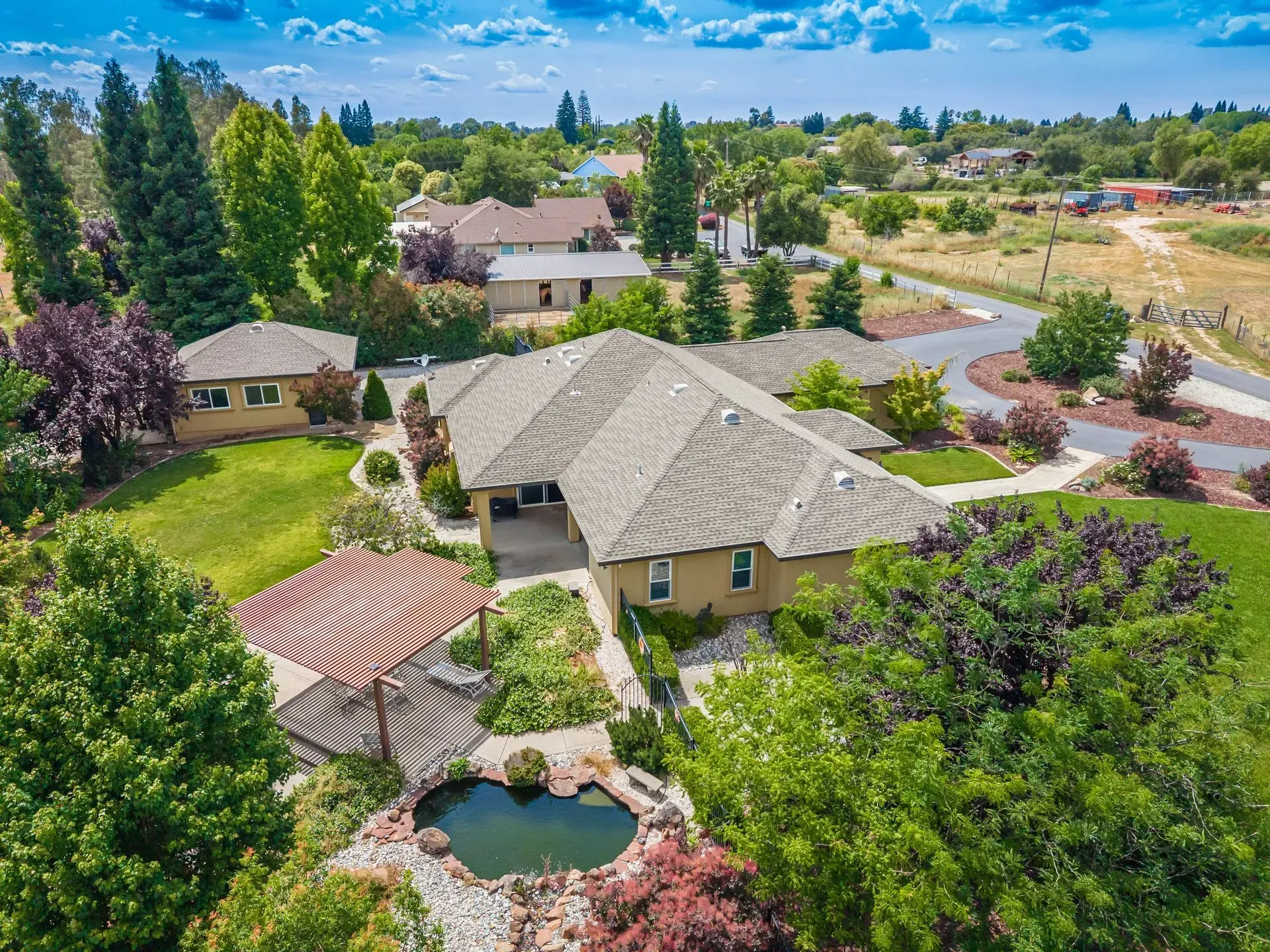 Aerial view of the expansive backyard featuring a private pond and custom loggia patio at this luxury real estate property in Loomis, CA.