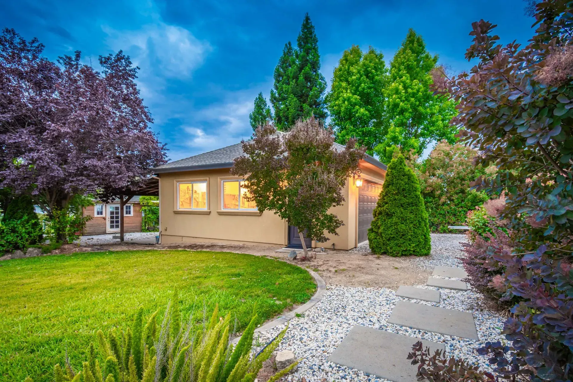 Fully insulated detached 4-car tandem garage with ADU conversion potential at dusk, a top feature in this Loomis home for sale.