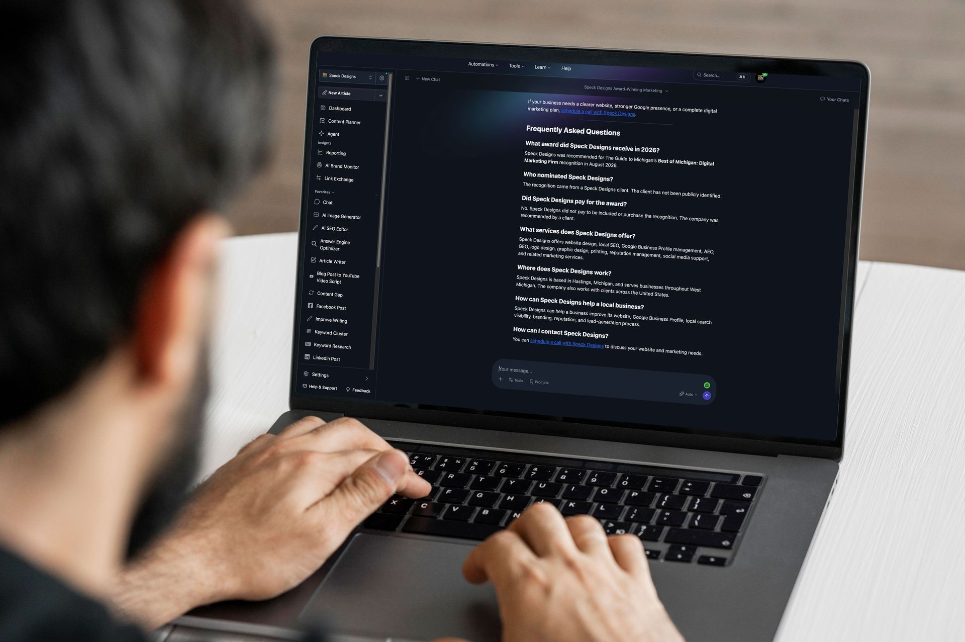 Person typing on a laptop displaying dark-themed code on a desk